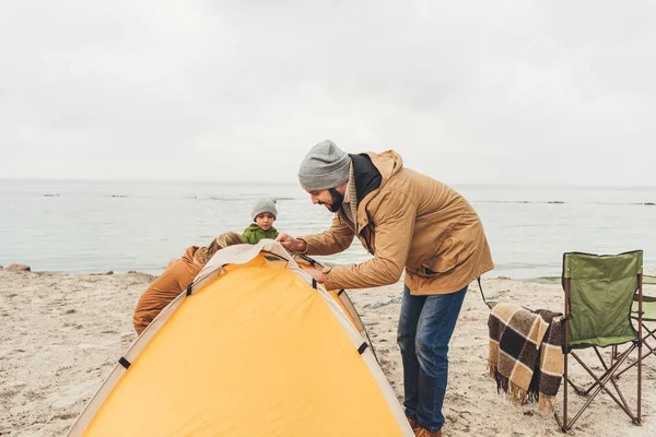 Man intalling camping tent on seahore — Stock Photo