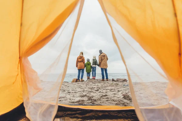 Family standing together on seashore — Stock Photo