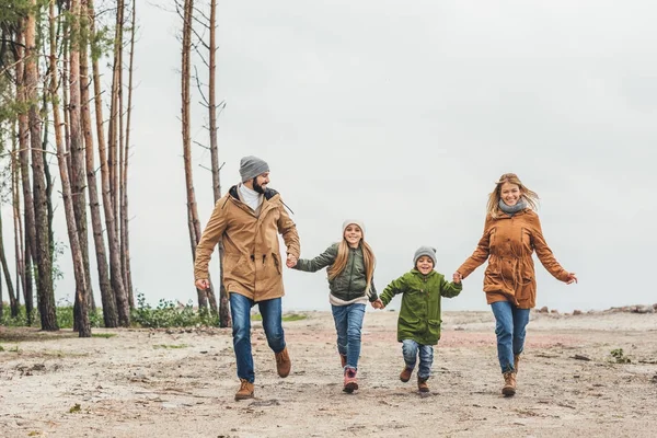 Famiglia che corre e si tiene per mano — Foto stock