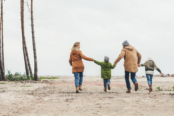 Family running and holding hands — Stock Photo