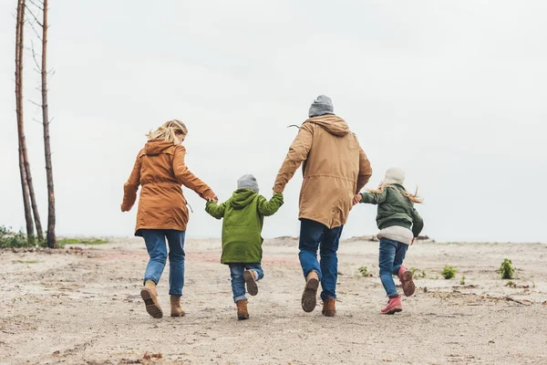 Familia corriendo y tomados de la mano - foto de stock