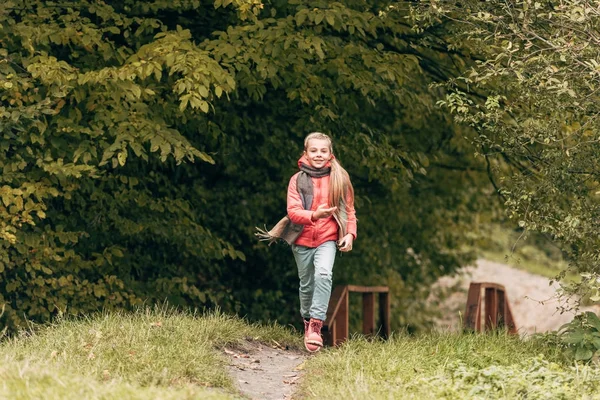 Niño corriendo en el parque de otoño - foto de stock