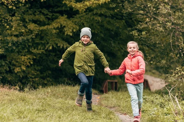 Niños corriendo en el parque de otoño - foto de stock