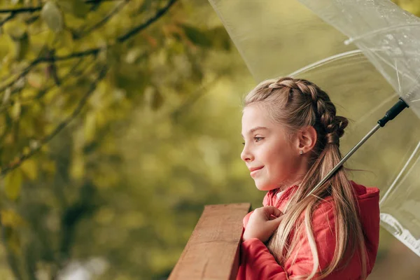Child with umbrella in autumn park — Stock Photo