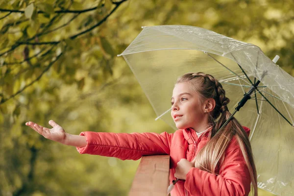 Child with umbrella in autumn park — Stock Photo