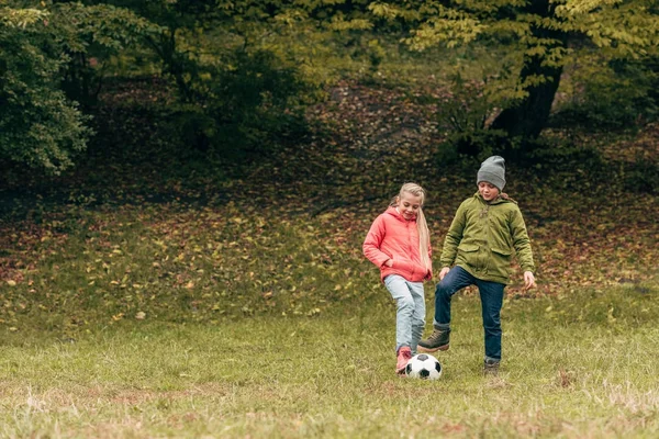 Kids playing soccer in park — Stock Photo