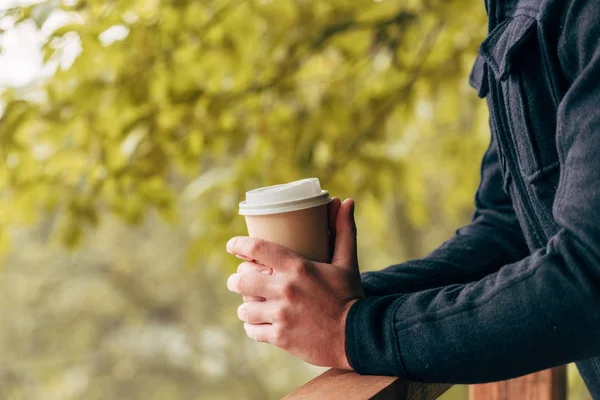 Uomo con bicchiere di carta nel parco — Foto stock