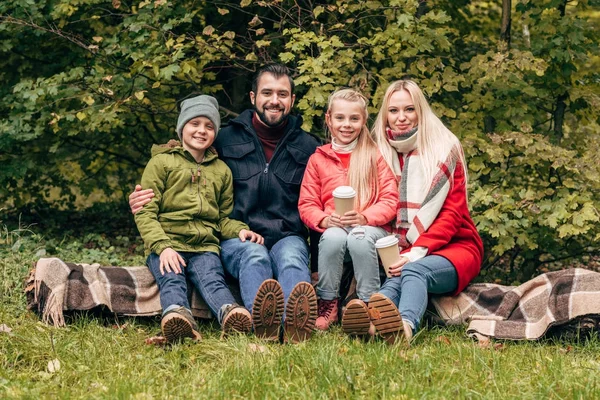 Family with paper cups in park — Stock Photo