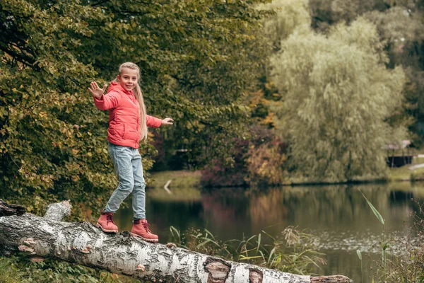 Bambino che cammina sul log in parco — Foto stock