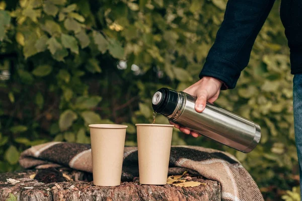 Mann gießt Tee aus Thermoskanne — Stockfoto