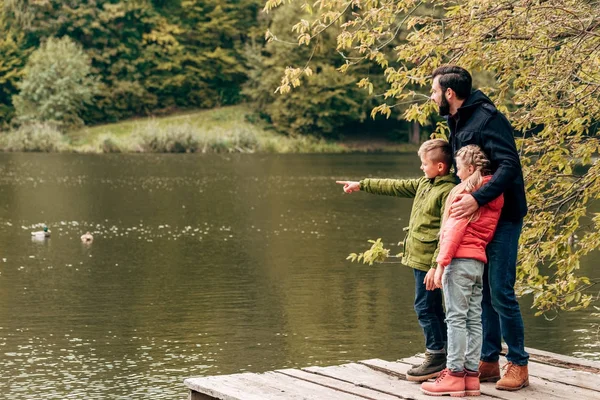 Vater mit Kindern schaut auf See — Stockfoto