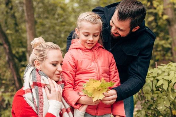 Familia sosteniendo hojas de otoño en el parque - foto de stock