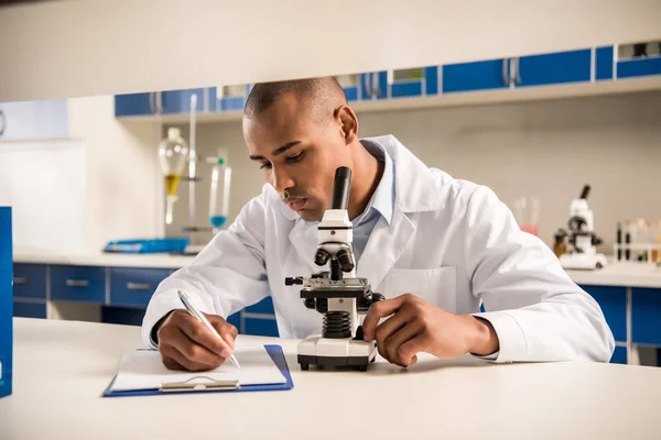 Technician using microscope — Stock Photo