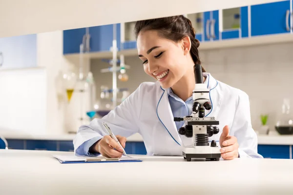 Lab technician taking notes — Stock Photo