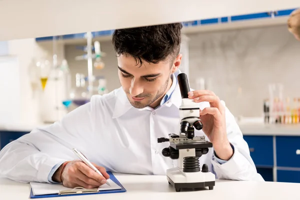 Técnico usando microscópio em laboratório — Fotografia de Stock