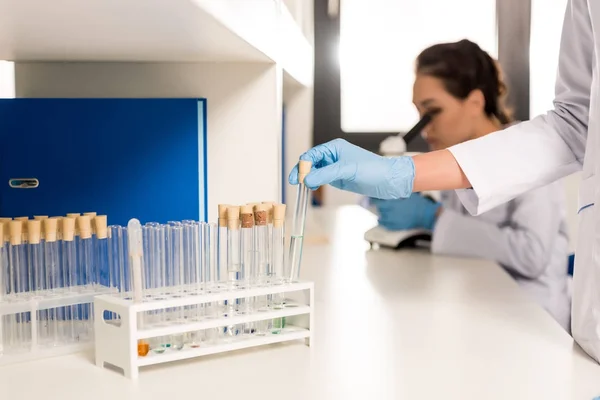 Cientista que trabalha com tubos de ensaio — Fotografia de Stock