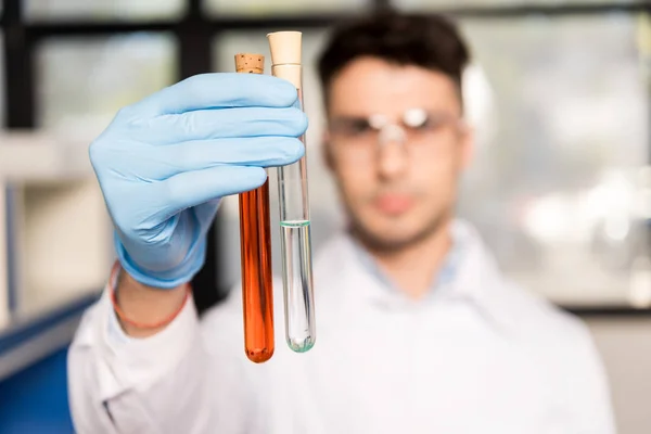 Scientist holding test tubes — Stock Photo