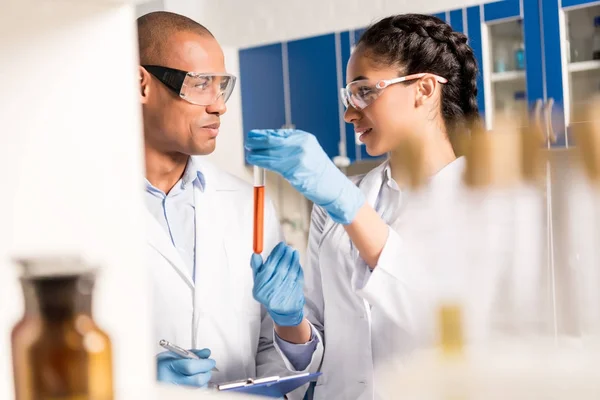 Scientists analyzing test tubes — Stock Photo