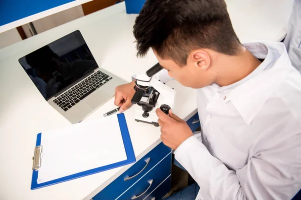 Químico trabalhando com microscópio — Fotografia de Stock