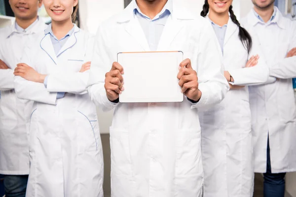 Team of doctors with blank card — Stock Photo