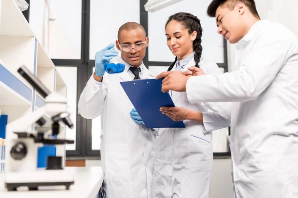 Medical workers analyzing test tube — Stock Photo