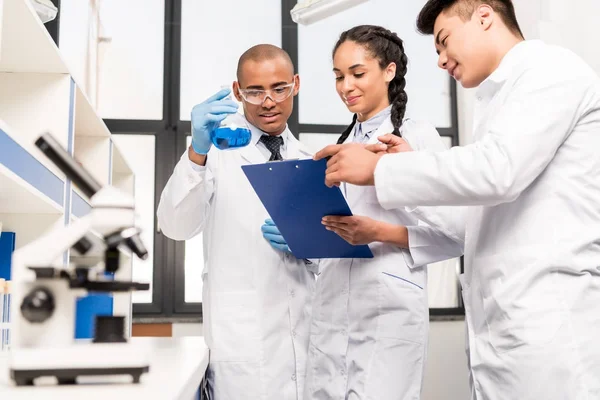 Trabajadores médicos analizando el tubo de ensayo - foto de stock