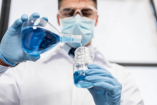 Scientist pouring reagent into jar — Stock Photo