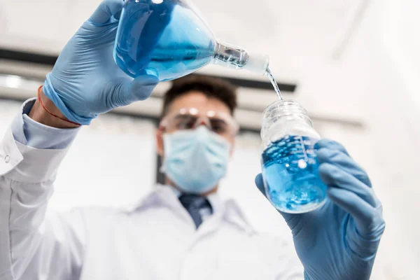 Scienziato versando reagente in vaso — Foto stock