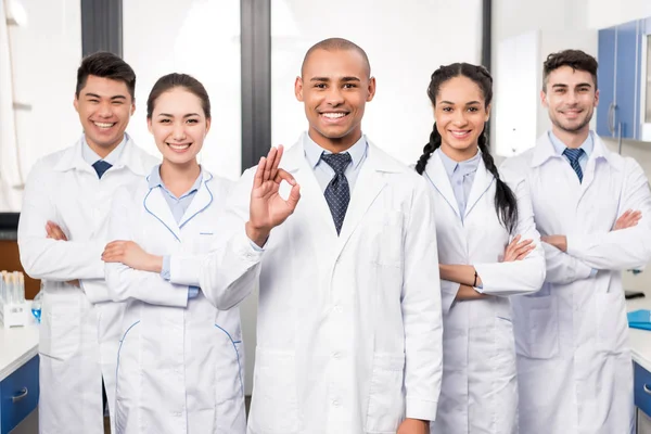 Doctor con equipo mostrando señal aceptable - foto de stock