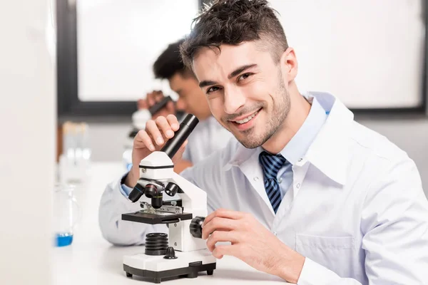 Médico trabajando con microscopio - foto de stock