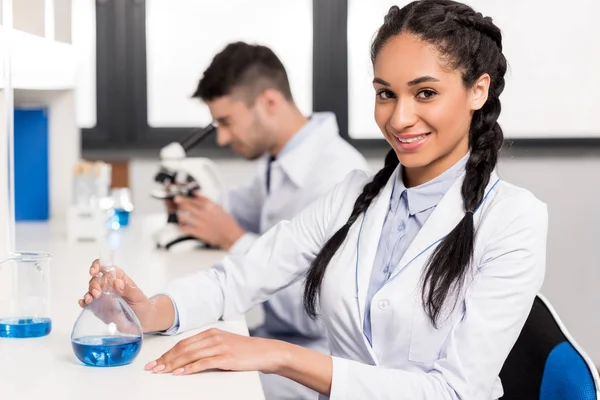 Científico en laboratorio con tubo de ensayo - foto de stock