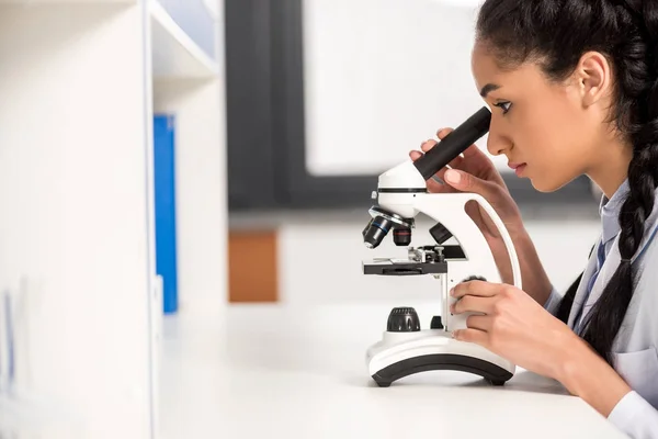 Cientista que trabalha com microscópio — Fotografia de Stock