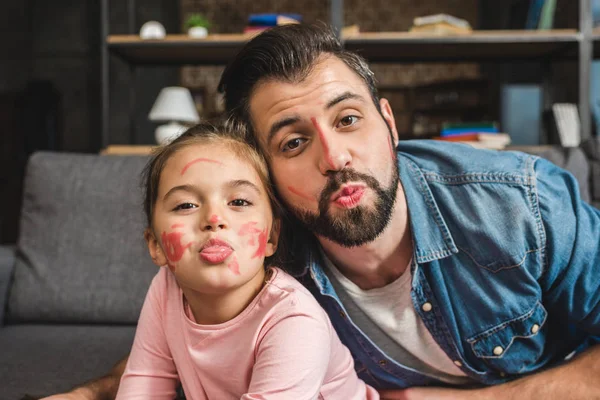 Padre e hija con caras pintadas - foto de stock