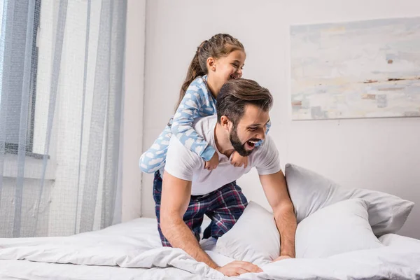 Father and daughter playing in bed — Stock Photo