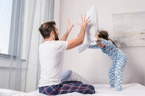 Padre e hija jugando pelea de almohadas - foto de stock