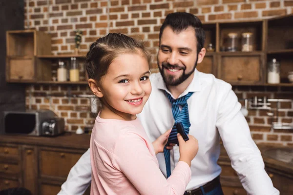 Daughter tying up necktie for father — Stock Photo