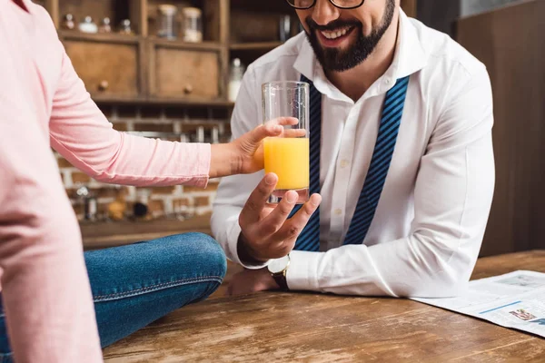 Padre dando vaso de jugo hija - foto de stock