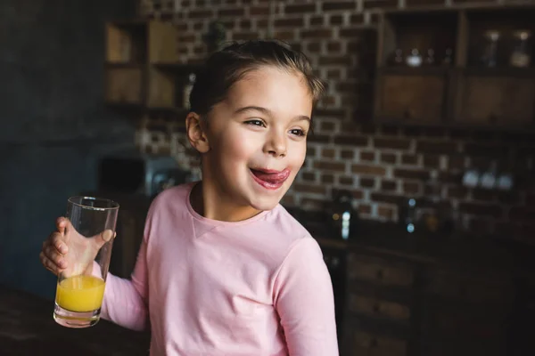 Child drinking orange juice — Stock Photo