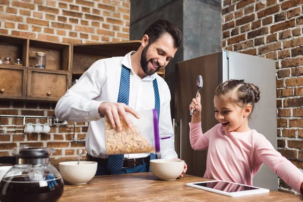 Pai fazendo café da manhã de cereais para filha — Fotografia de Stock