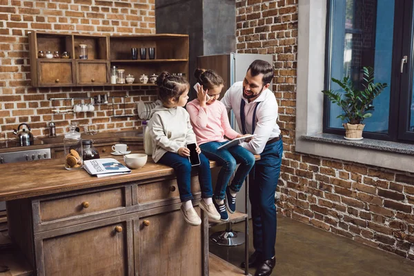 Padre e hijas en la cocina - foto de stock