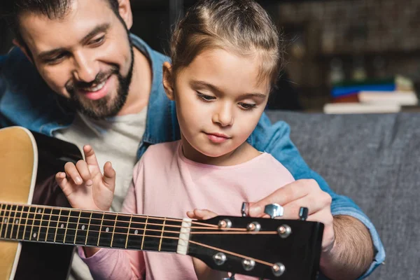 Father learning daughter to play guitar — Stock Photo
