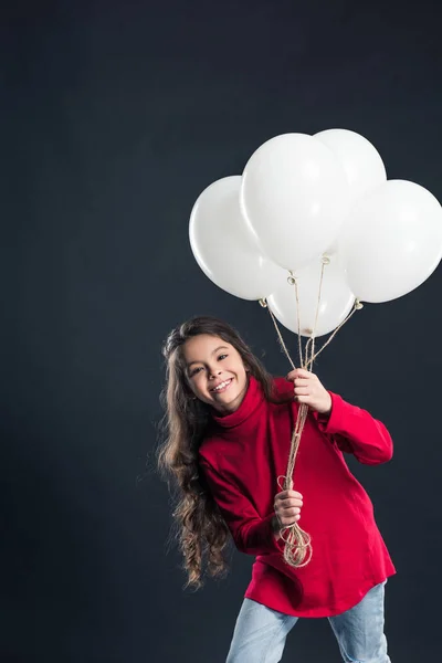 Child holding bundle of balloons — Stock Photo