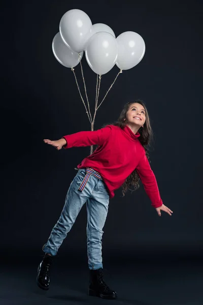 Kid imitating flying with balloons — Stock Photo