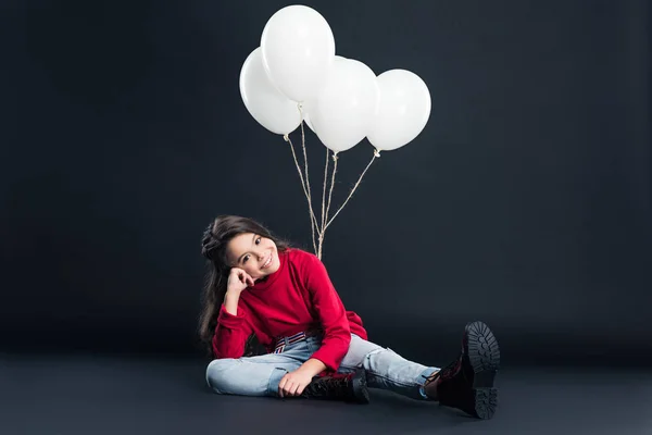 Kid sitting tied with bundle of balloons — Stock Photo