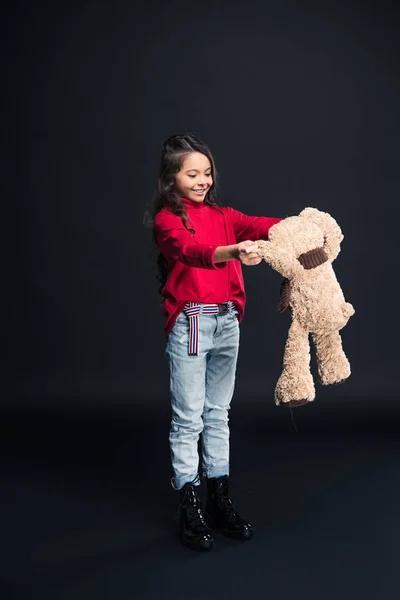 Criança sorridente brincando com ursinho de pelúcia — Fotografia de Stock
