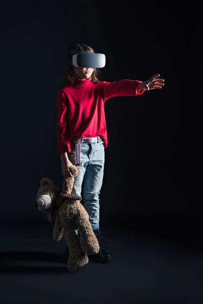 Child in VR headset holding teddy bear — Stock Photo