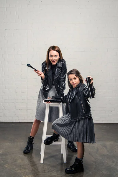 Mother and daughter with makeup brush — Stock Photo