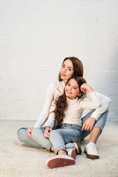 Mutter und Tochter sitzen auf Teppich — Stockfoto