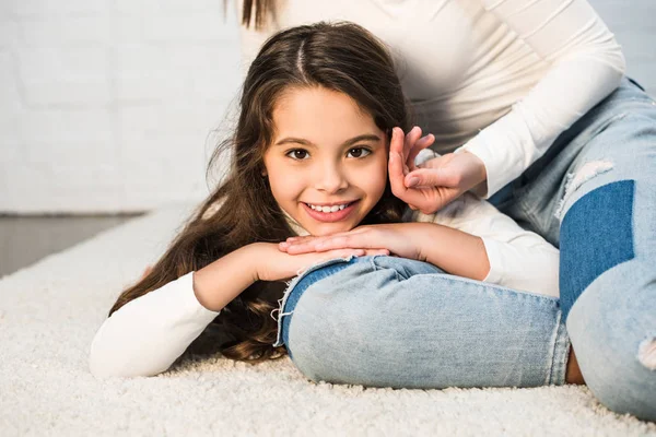 Daughter lying on mothers leg — Stock Photo