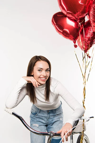 Mujer apoyada en bicicleta con globos - foto de stock